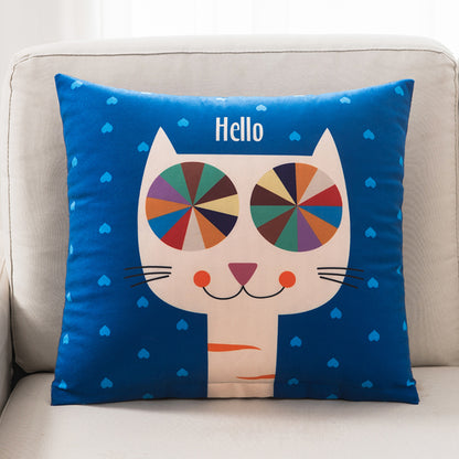 Decorative pillow with a colorful cat design and 'Hello' text on a blue background, placed on a beige couch.