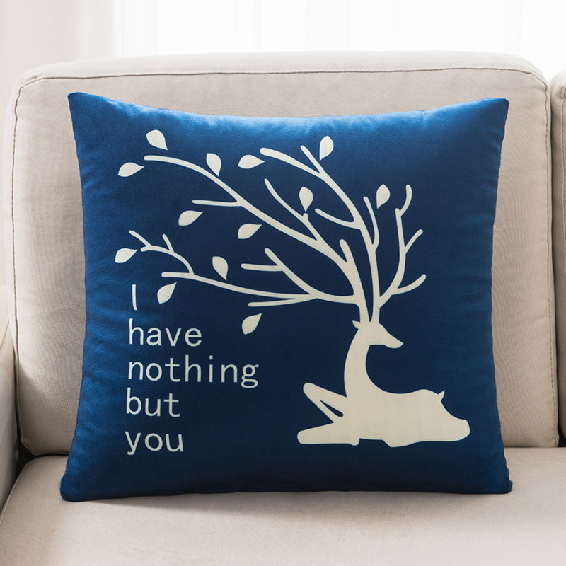 Blue pillow with white tree design and text on a beige couch