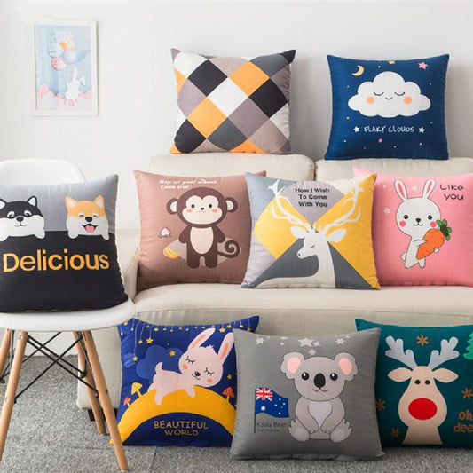 Various decorative pillows with cartoon designs on a sofa.