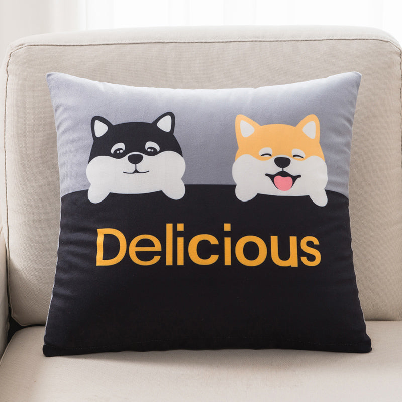 Decorative pillow with cartoon dogs and 'Delicious' text on a couch.