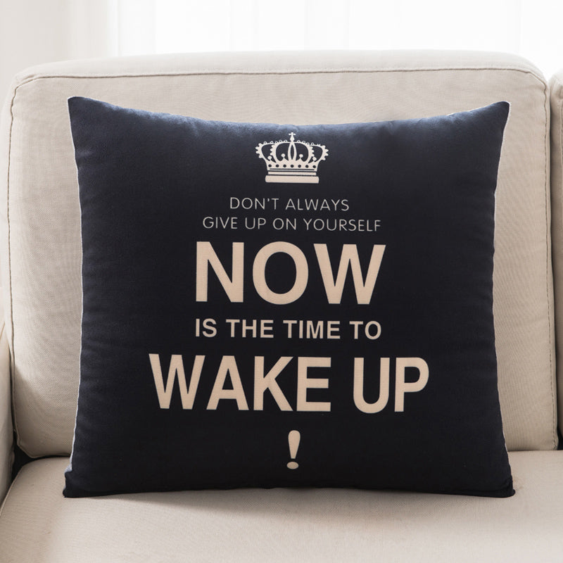 Black pillow with motivational quote on a beige couch