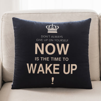 Black pillow with motivational quote on a beige couch
