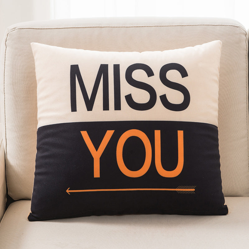 Decorative pillow with 'MISS YOU' text on a beige couch