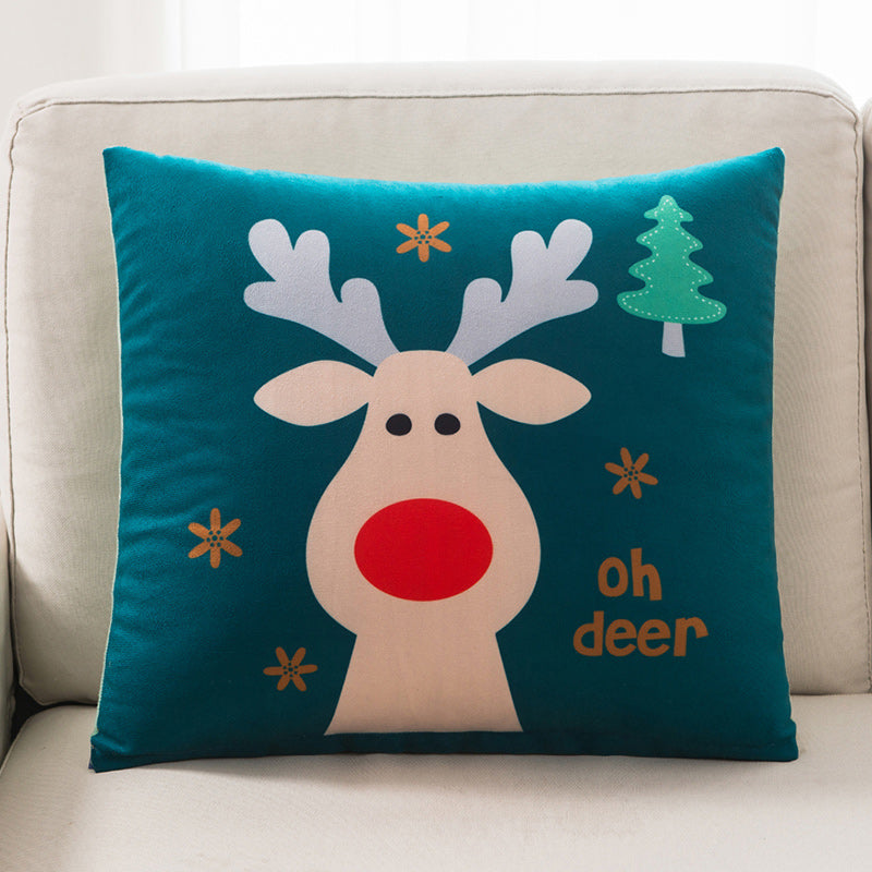 Decorative pillow with a reindeer design and 'oh deer' text on a teal background, placed on a beige couch.
