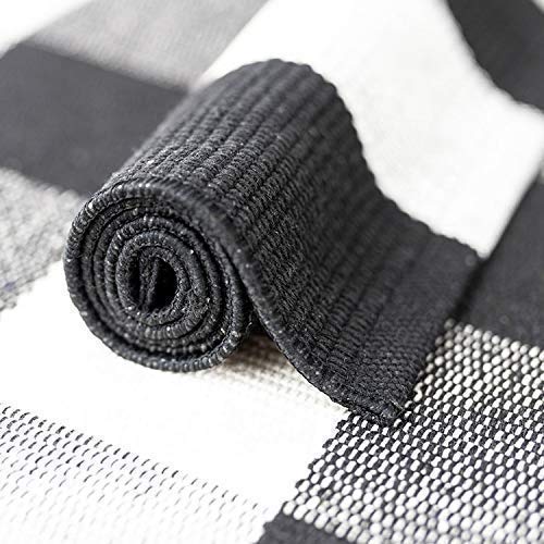 Portland cotton buffalo check runner rug rolled to show flat-weave construction and non-slip mesh backing — black and white, Studio Reign