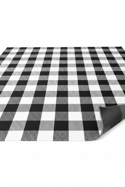 Portland cotton buffalo check runner rug rolled to show flat-weave construction and non-slip mesh backing — black and white, Studio Reign